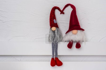 Téléchargez les photos : Gonks scandinaves au chapeau rouge. Gnomes de Noël sur l'étagère en bois blanc. Espace libre pour le texte. Noel ou Nouvel An concept, carte de voeux - en image libre de droit