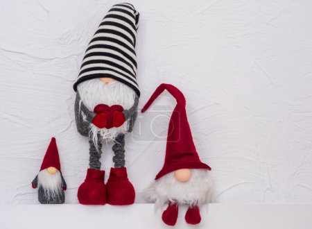 Téléchargez les photos : Collections de gnomes de Noël. Gonks scandinaves ou elfes sur l'étagère en bois blanc. Noel et Nouvel An concept, carte de voeux, espace de copie - en image libre de droit