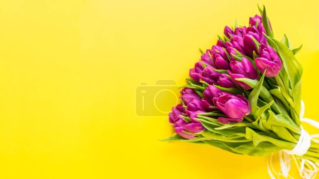 Beautiful romantic bouquet of pink tulips on the yellow background. Congratulations on March 8, Birthday, Mother's Day, Valentines day