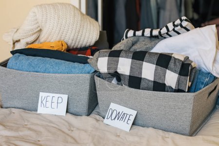 Photo for Closet sorting and organization. Two baskets with closes to keep and donate. Home cleaning - Royalty Free Image