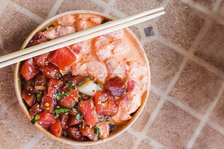 Photo for Two types of delicious traditional hawaiian poke in a paper bowl, top view - Royalty Free Image