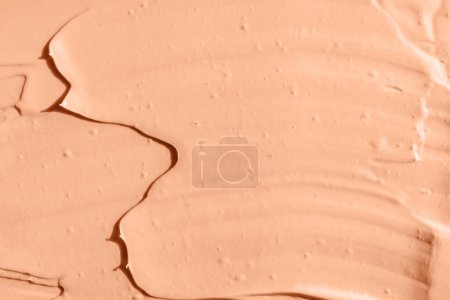 Peach color cosmetic, paint or clay texture close-up, abstract background, natural sunlight