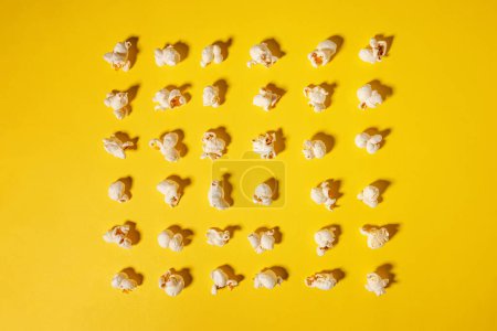 Palomitas de maíz aisladas sobre fondo amarillo brillante, noche de cine