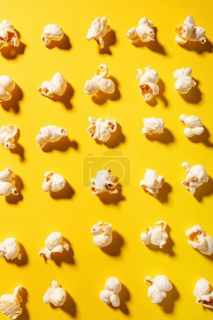 Tasty fresh popcorn on yellow color background, top view