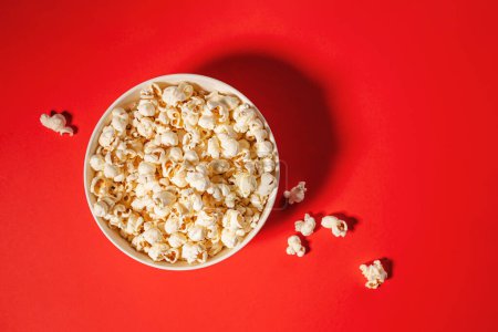 Popcorn in einer Schleife isoliert auf rotem Hintergrund, Filmabend