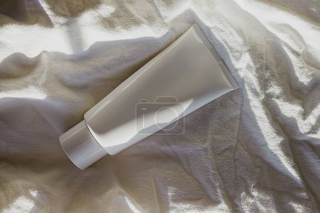 Photo for White body lotion tube on the bed in morning light - Royalty Free Image