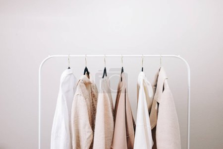 Photo for Wardrobe essentials of white and beige colors, stylish woman's closing on the rack - Royalty Free Image