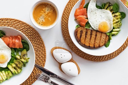 Photo for Healthy Breakfast bowls with salmon, avocado, toast and eggs, top view - Royalty Free Image