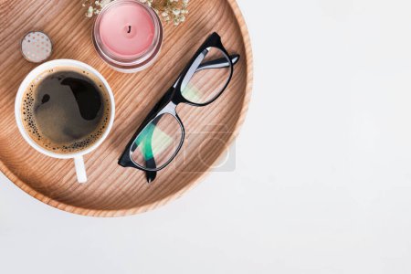 Photo for Morning Coffee, candle and reading glasses on the wooden tray, top view - Royalty Free Image
