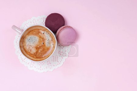 Photo for Cup of coffee and french macarons on pink background, top view - Royalty Free Image