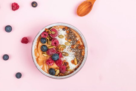 Photo for Breakfast smoothie bowl topped with berries and coconut flakes. Healthy nutrition, top view - Royalty Free Image