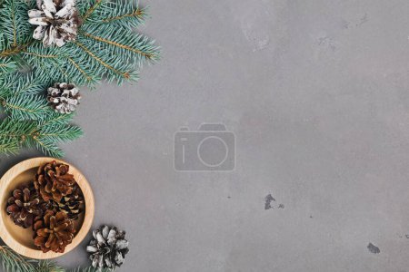 Photo for Fir branches and pine cones on grey stone surface, overhead view. Christmas background - Royalty Free Image
