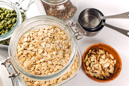 Photo for Glass jar full of rolled oats close-up, healthy nutrition ingredient - Royalty Free Image