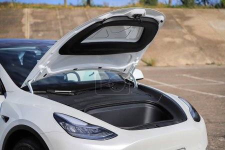 Foto de Maletero abierto frente a un coche blanco Tesla - Imagen libre de derechos