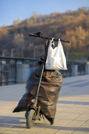 Foto de Bolsas de basura en un scooter eléctrico - Imagen libre de derechos