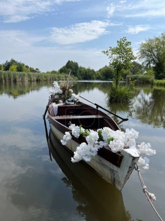 Téléchargez les photos : Love Boat décoré de fleurs blanches. Bateau de mariage sur le lac en été horizone. - en image libre de droit