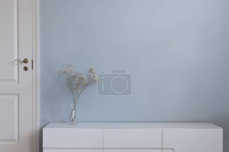Téléchargez les photos : Meubles de salon sur le sol en face du mur vide bleu et porte blanche. Décor de maison en vase, style intérieur nordique minimaliste. - en image libre de droit