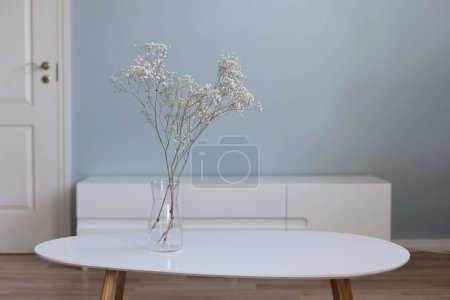 Foto de Muebles de salón, mesa de café y televisor frente a la pared azul vacía. Decoración para el hogar en jarrón, escandinavo diseño de interiores. - Imagen libre de derechos