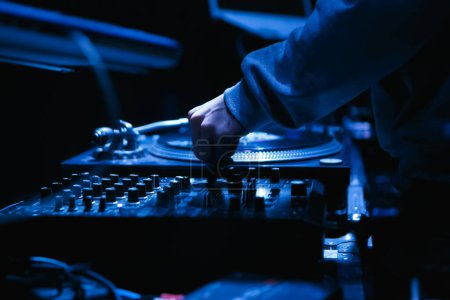 Foto de Hip hop dj mezcla de música en la fiesta en el club nocturno. Discoteca disc jockey juega conjunto con el dispositivo mezclador de sonido - Imagen libre de derechos
