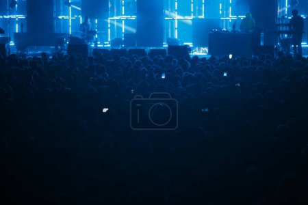Photo for Huge concert crowd in fan zone. Big group of people listening to music on festival in night club - Royalty Free Image