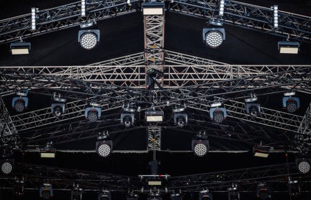 Concert stage lighting mounted on high rack. Professional music festival lights installed on stadim scene