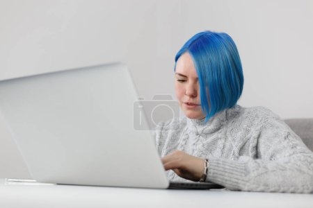 Téléchargez les photos : Focused millennial woman typing text on notebook keyboard. Freelancer female person works on modern laptop computer at home - en image libre de droit