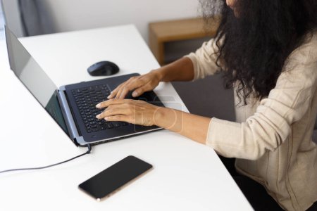 Foto de BIPOC programmer woman typing code on laptop computer. Freelancer POC works on modern notebook pc at home, shot from above - Imagen libre de derechos