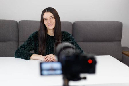 Photo for Cheerful influencer person filming video blog. Friendly young woman shooting educational footage with camcorder at home - Royalty Free Image