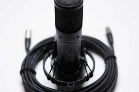 Téléchargez les photos : Professional condenser microphone and wire in close up. High quality audio equipment for sound recording studio - en image libre de droit