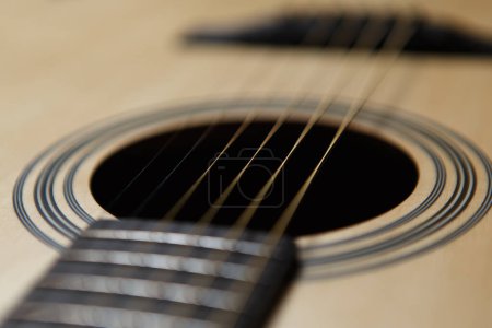 Téléchargez les photos : Six string acoustic guitar in close up. Focus on metal strings and hole in sound board - en image libre de droit