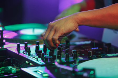 Téléchargez les photos : Hip hop dj mixing music with sound mixer and turntables. Club disc jockey playing musical set on stage - en image libre de droit