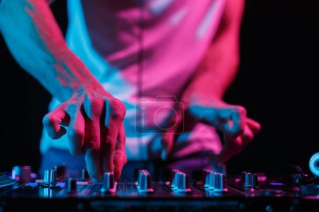 Photo for Party DJ mixing musical tracks. Close up photo of club disc jockey adjusting volume on sound mixer - Royalty Free Image
