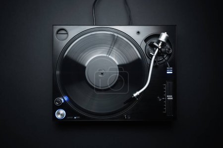 Photo for Flat lay photo of DJ turntable playing vinyl record on black background. Professional analog record player shot directly from above - Royalty Free Image