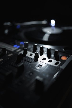 Téléchargez les photos : DJ sound mixer and vinyl turntable in night club. Professional disc jockey setup on stage - en image libre de droit