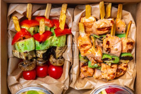 Photo for Flat lay photo of box with grilled salmon fish fillet and vegetables on sticks. Healthy food delivery - Royalty Free Image