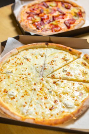 Photo for Delicious Italian pizza delivered for lunch in cardboard boxes. Two tasty pizzas cooked on oven for dinner - Royalty Free Image