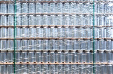 Foto de Stack of new aluminum cans for cold beverages. Big pallet of metal containers for alcholic and refreshing drinks - Imagen libre de derechos