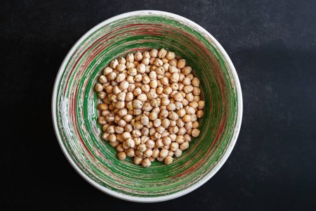 Téléchargez les photos : Flat lay photo of a bowl with dry chickpeas. Raw Egyptian Pea for healthy eating - en image libre de droit