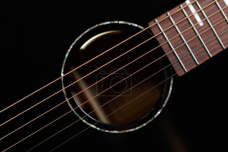 Foto de Guitar sound hole and strings shot from above in flat lay style. Beautiful black acoustic guitar in close up - Imagen libre de derechos