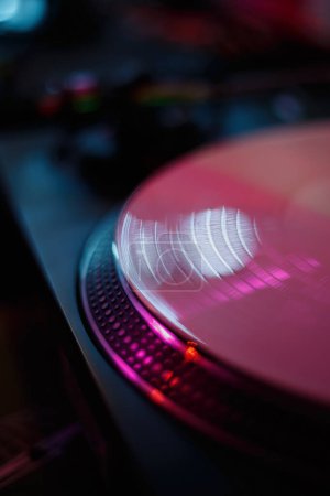 Foto de White vinyl record with music on turntable. Analog audio disc on turn table. DJ equipment on party in night club. Listen to the music in hi fi - Imagen libre de derechos