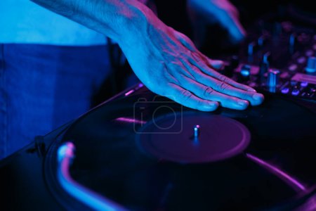Foto de Hip hop disc jockey rasca el disco de vinilo en el tocadiscos. Club dj rayando récords en tocadiscos - Imagen libre de derechos