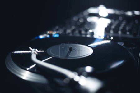 Foto de Hip hop DJ turtnables and sound mixer in night club. Plays music set with professional disc jockey setup - Imagen libre de derechos