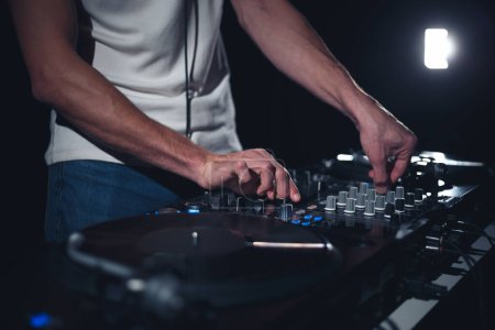 Foto de Concierto DJ tocando música en el escenario. Discoteca disc jockey mezclando pistas de música en la fiesta - Imagen libre de derechos