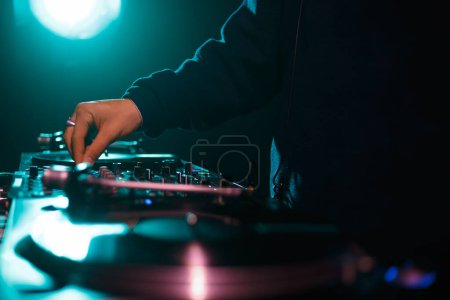 Foto de Hip hop dj toca música en la fiesta en el club nocturno. Disco jockey ajuste de volumen y reguladores de frecuencia en mezclador de sonido - Imagen libre de derechos