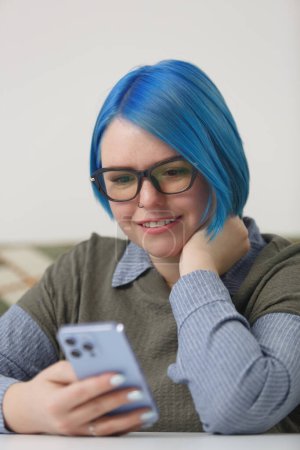 Téléchargez les photos : Femme aux cheveux bleus dans des lunettes de navigation application mobile sur téléphone intelligent moderne - en image libre de droit