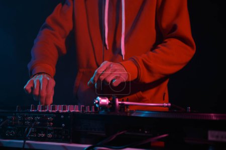 Téléchargez les photos : Club dj plays music on party in night club. Professional disc jockey mixing musical tracks on concert - en image libre de droit
