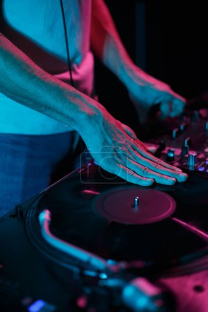 Photo for Hip hop dj scratching vinyl record on turntable player. Club disc jockey scratches records on rap concert in nightclub - Royalty Free Image