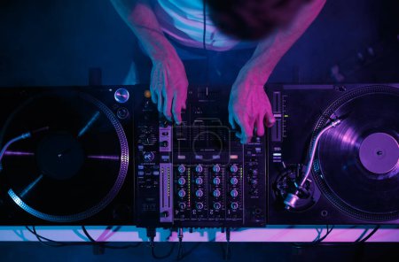 Foto de Hip hop dj toca música en concierto. Disco jockey mezclando pistas musicales con tocadiscos de vinilo y mezclador de sonido en discoteca - Imagen libre de derechos