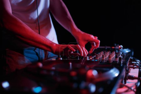 Foto de Techno party DJ mixing music on party with sound mixer and vinyl turntables - Imagen libre de derechos