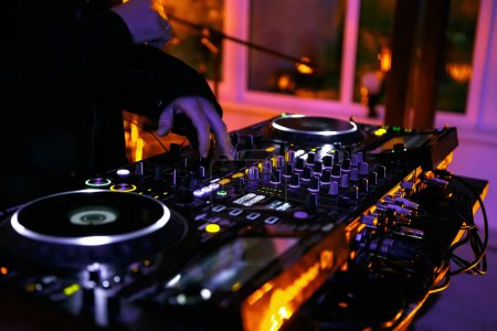 Téléchargez les photos : DJ fille jouer de la musique sur la fête dans la boîte de nuit. Mains de disc-jockey féminin mélangeant pistes musicales avec mixeur sonore et platines vinyles cd - en image libre de droit